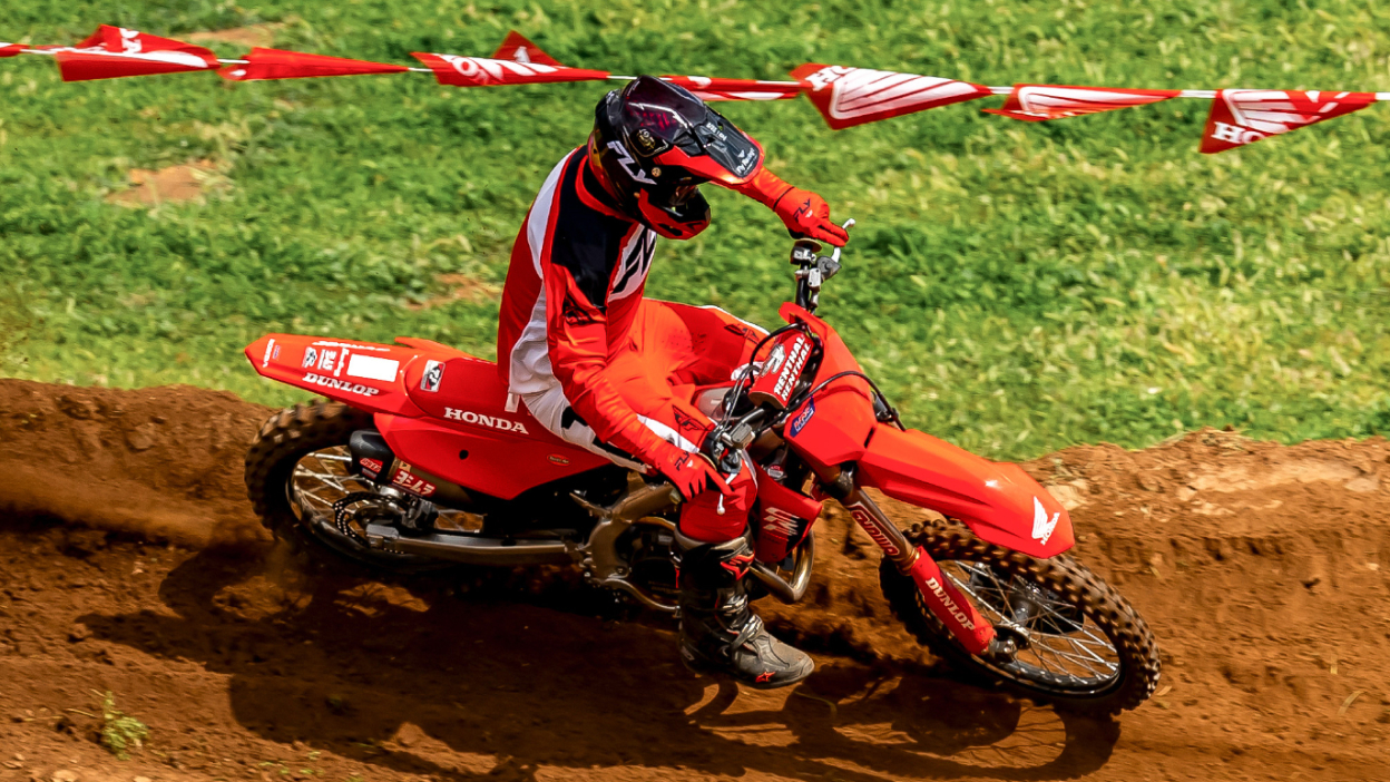 Rider making sharp turn going left on dirt track.