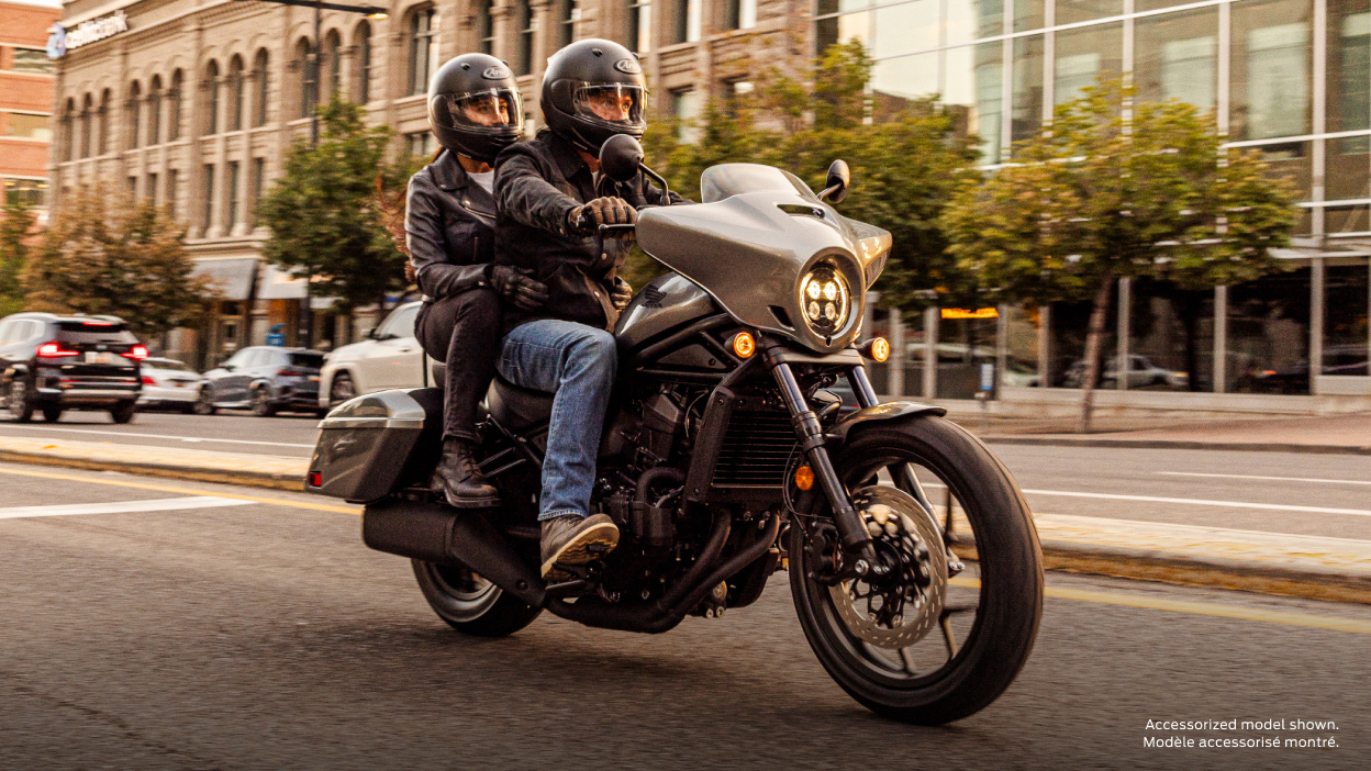 Rider going left on street on grey Rebel.